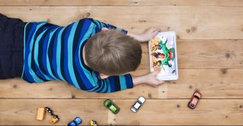 Boy playing Brawl Stars on his tablet on the floor
