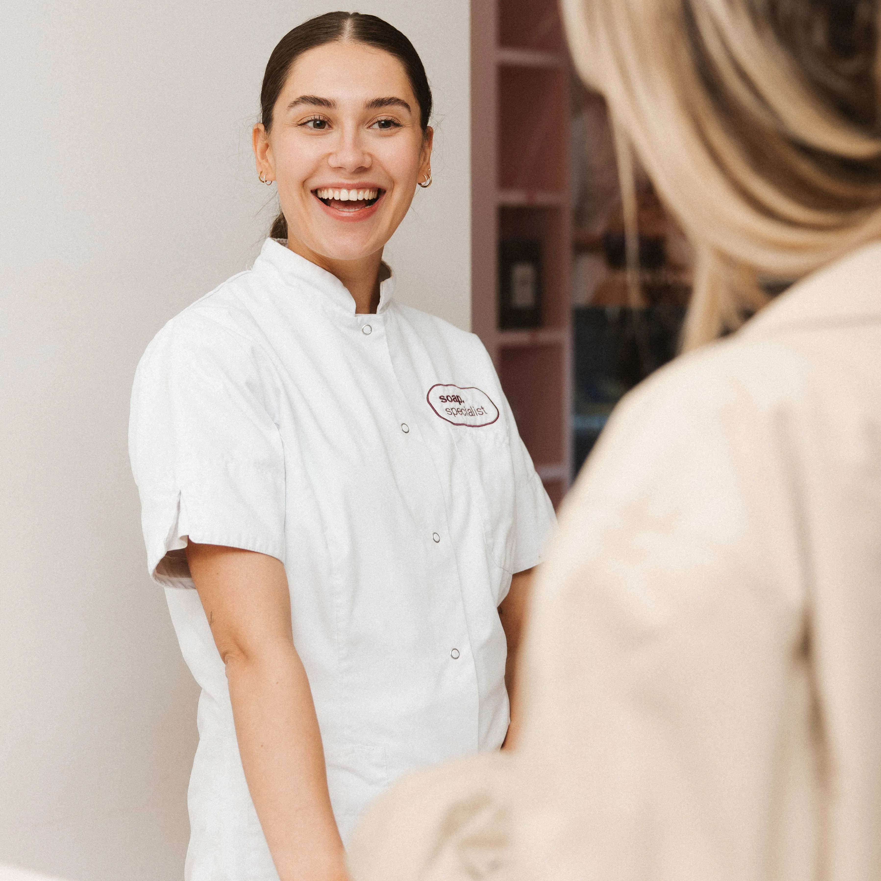Lachende medewerker van Soap in een witte jas