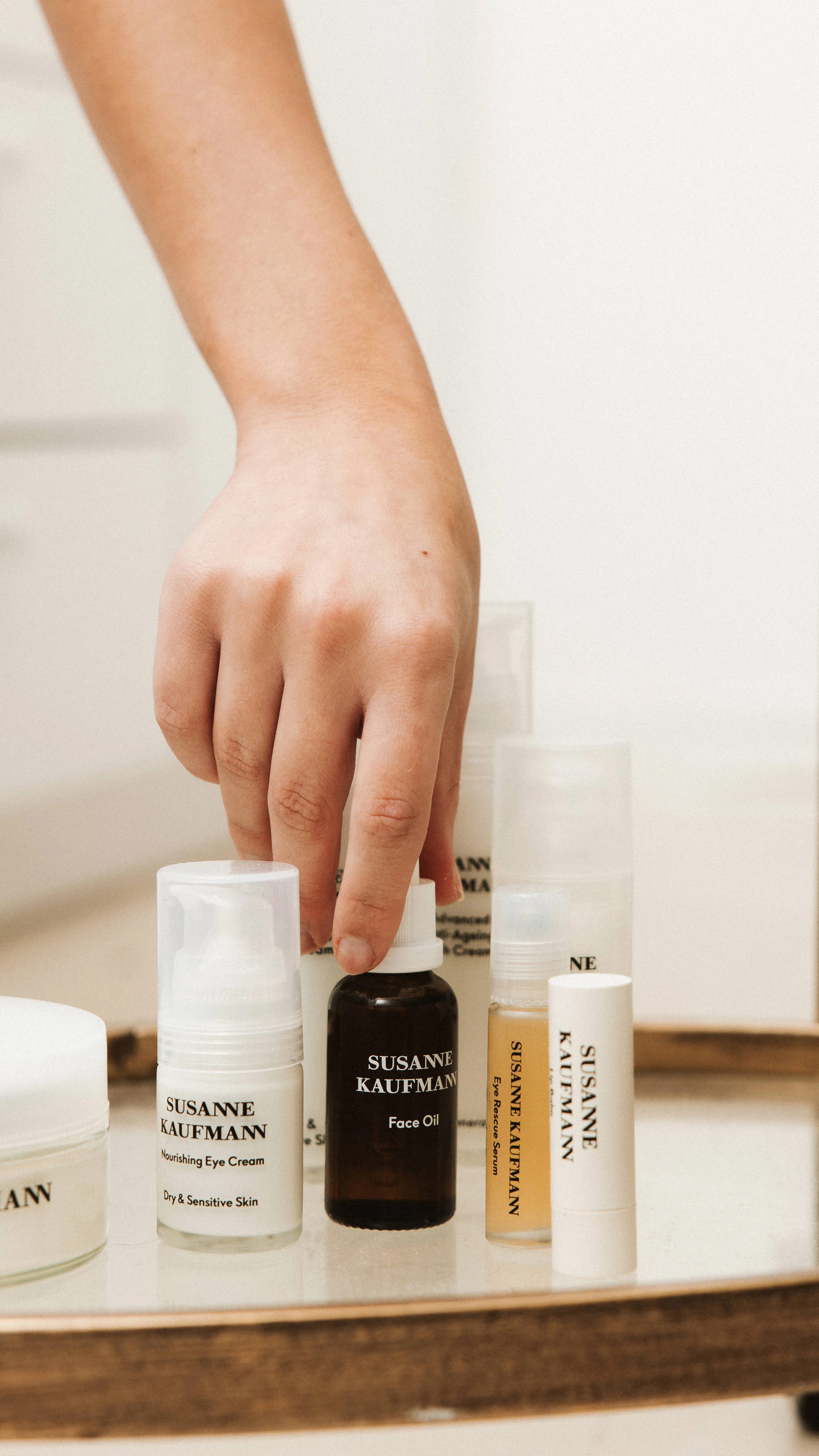 Hand pakt een serum uit de huidverzorging van Susanne Kaufmann