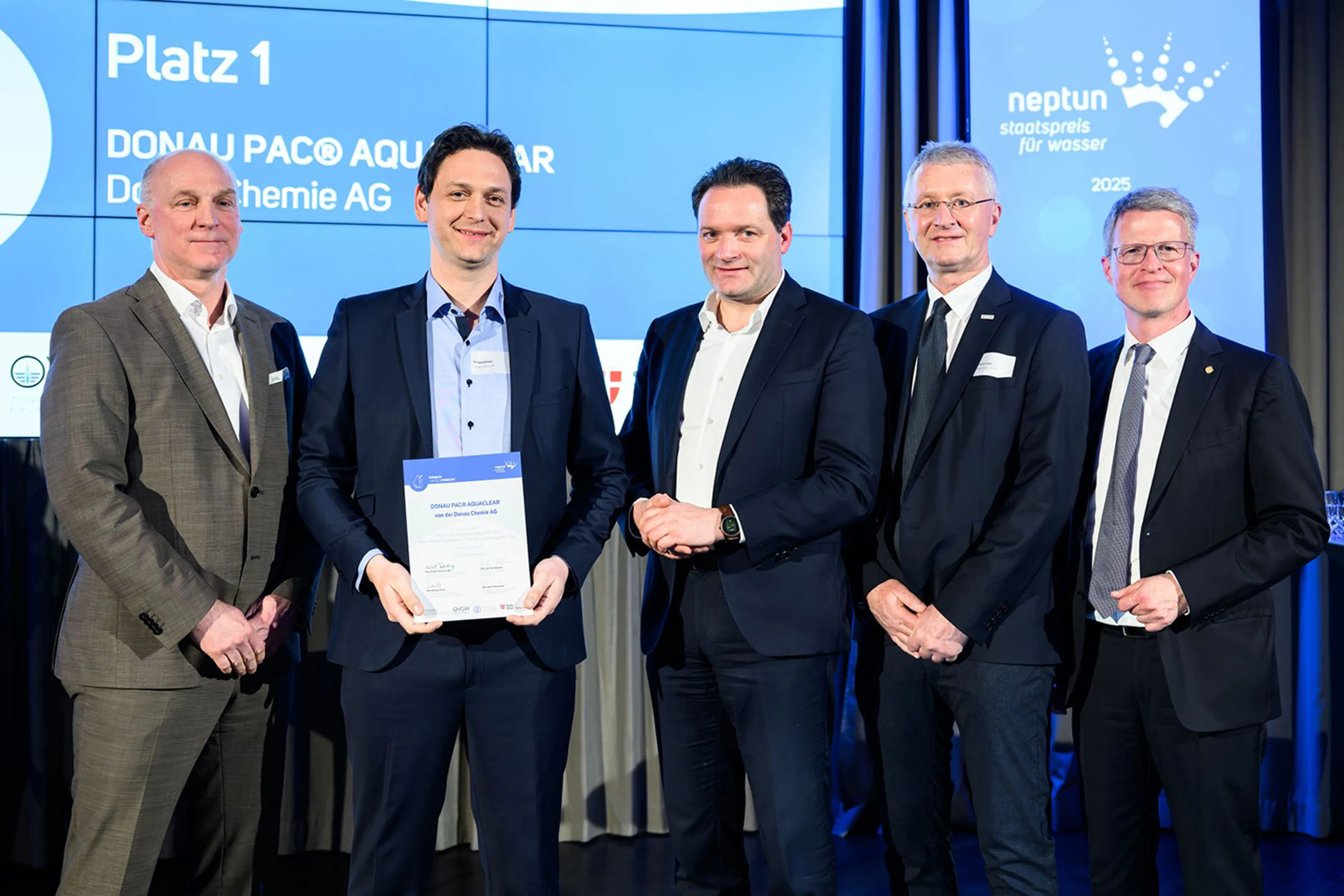 Personen halten Urkunde für Neptun Staatspreis für Wasser