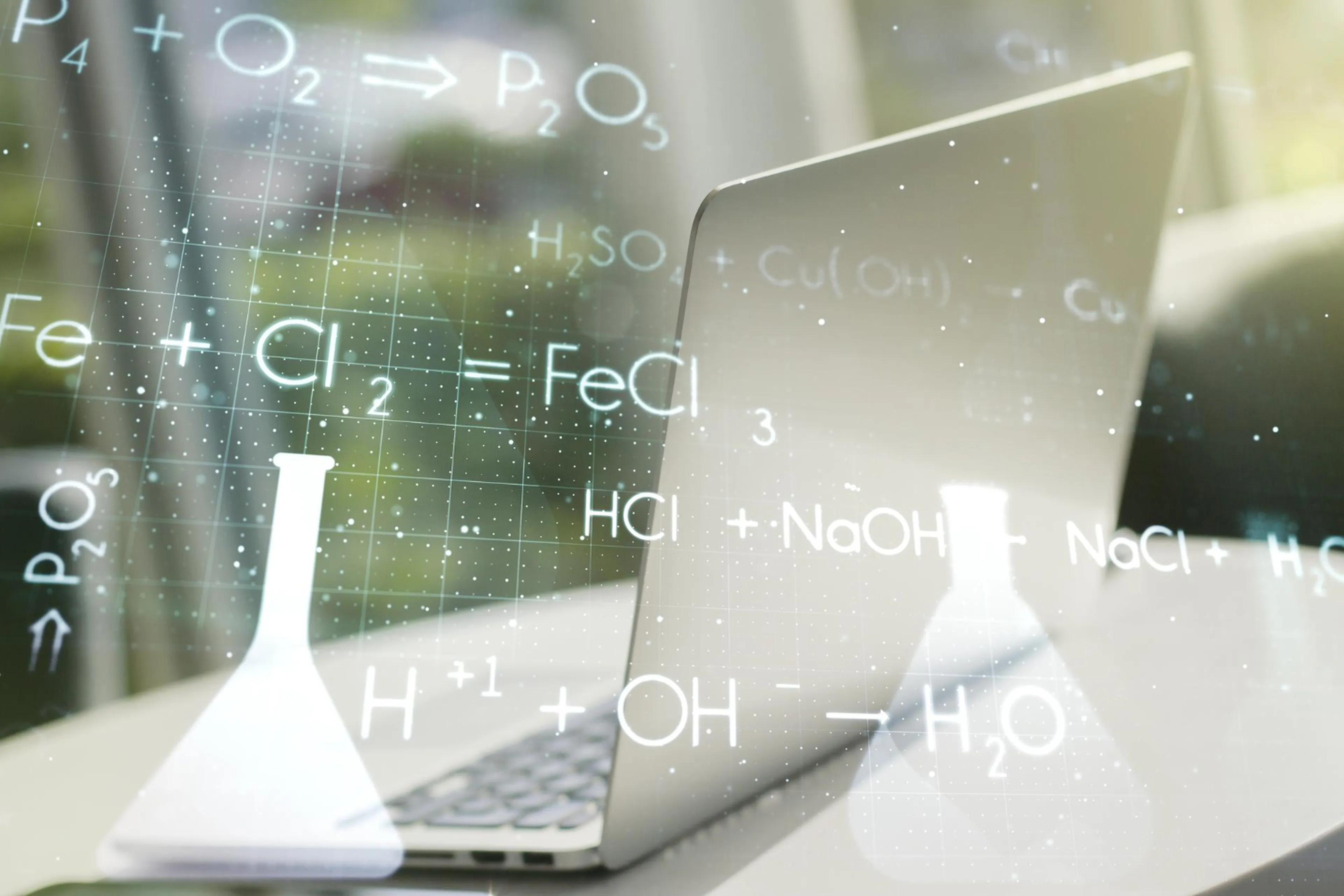 Open laptop with chemistry formulas overlay, featuring test tube and flask graphics, against a blurred outdoor background.