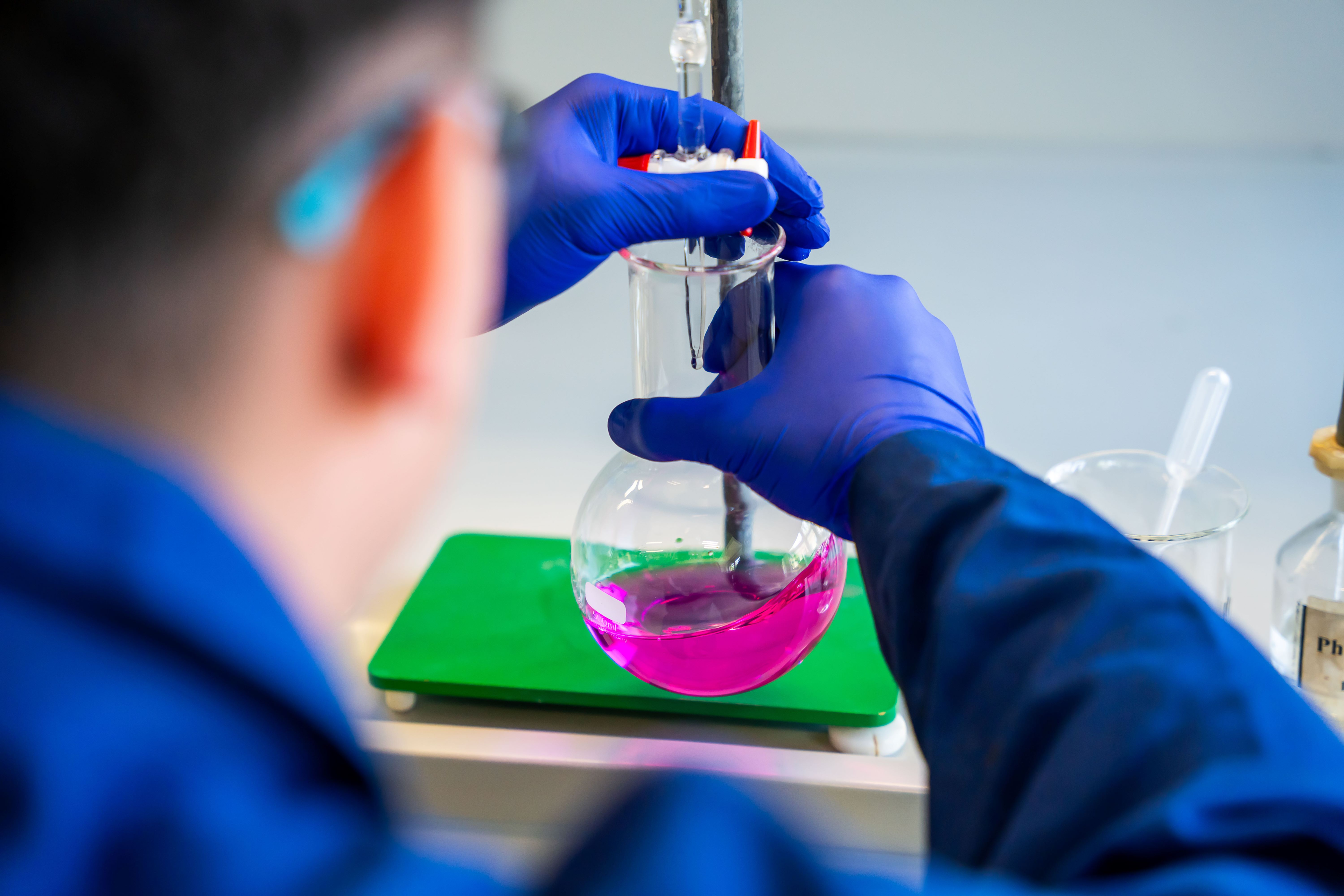 Mitarbeiter hantiert mit Chemiekolben