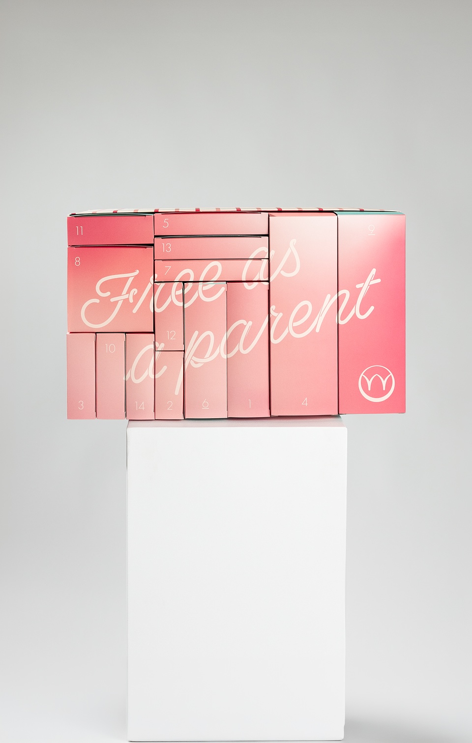 Pink Najell advent calendar with numbered compartments and cursive text "Free as a parent" displayed on a white pedestal.