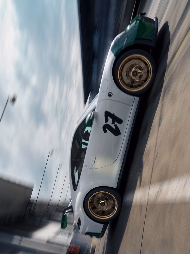 Blick auf die Seite des auf der Rennstrecke Nürburgring fahrenden Porsche 911 GT3 100 Jahre Nürburgring.