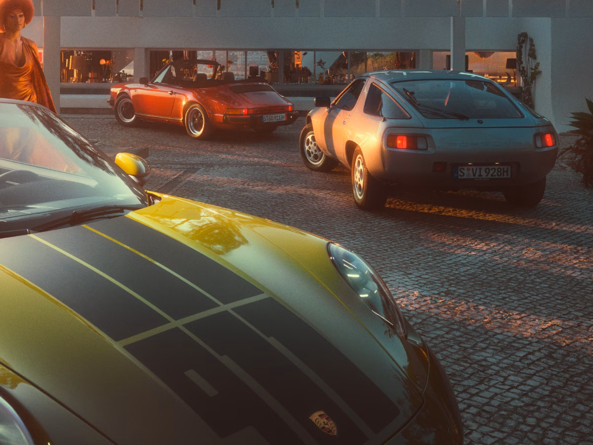 オリーブネオ塗装仕上げの  911 Spirit 70をボンネットから見たビュー。背景に見えるクラシックポルシェモデル。