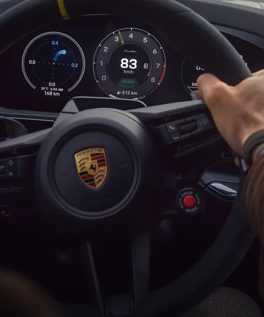 Interiör i Porsche Cayenne Turbo E-Hybrid Coupé med GT-Paket: detaljerad vy av head-up-displayen under körning på en tävlingsbana.