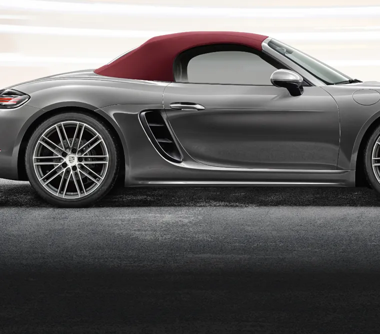 Vue latérale du Porsche 718 Boxster en Gris Quartz métallisé, axée sur la capote en toile.