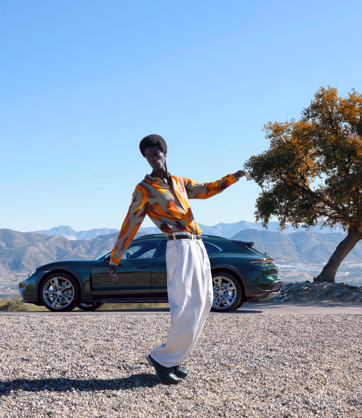 Porsche Taycan Turbo Cross Turismo in Oak Green Metallic Neo parked in the countryside. Side view. Person in the foreground.