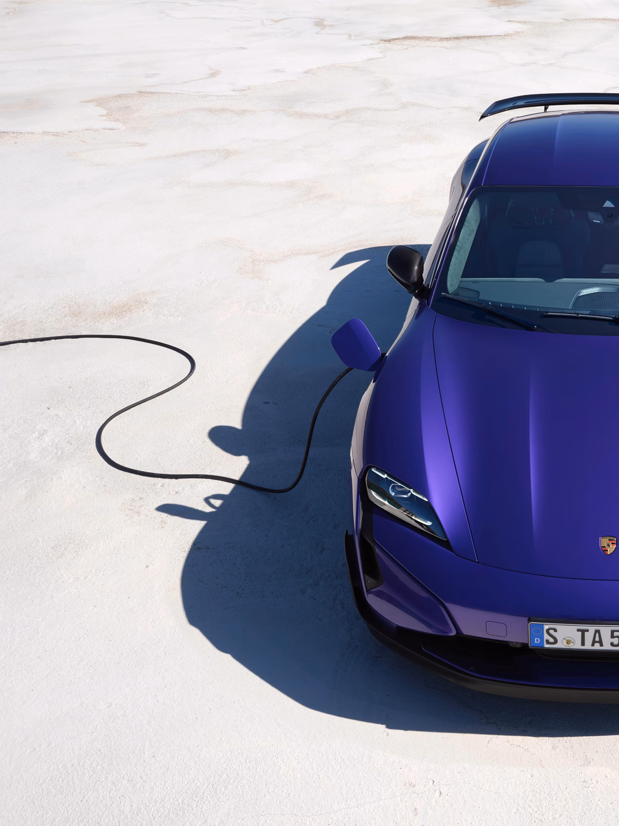 Porsche Taycan Turbo GT mit Weissach-Paket in Purpleskymetallic wird geladen. Blick von erhöhter Position auf die Front.