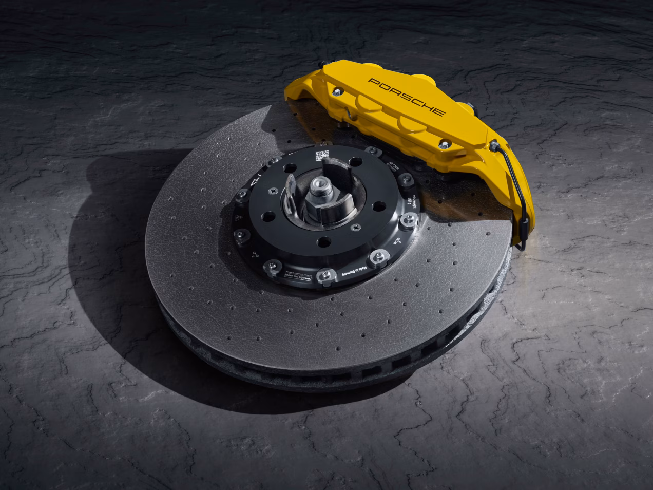 The Porsche Ceramic Composite Brake (PCCB) on a grey surface.