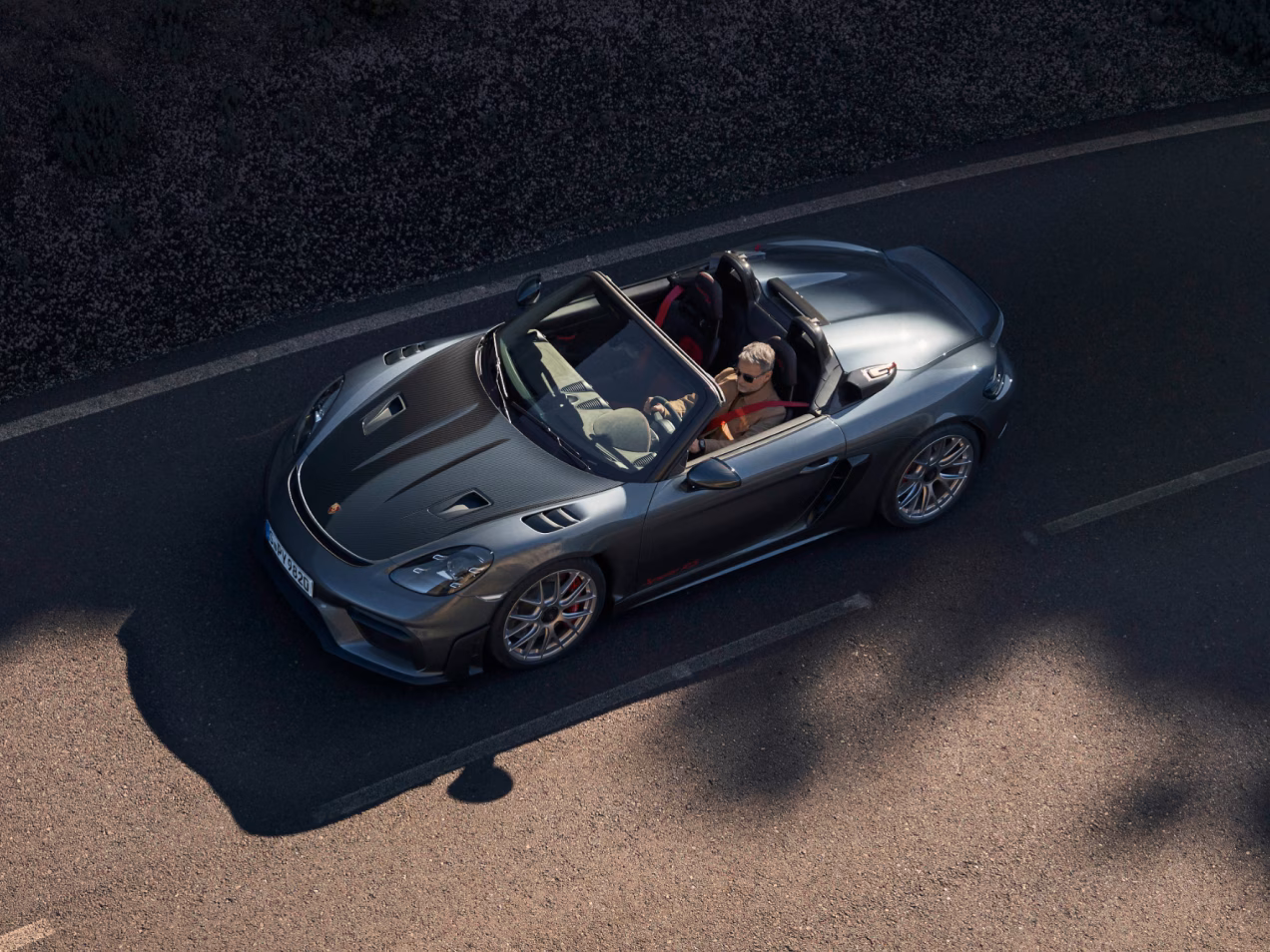 Top side view of the Porsche 718 Spyder RS in Vanadium Grey Metallic with Weissach package. Carbon-weave finish parts clearly visible.