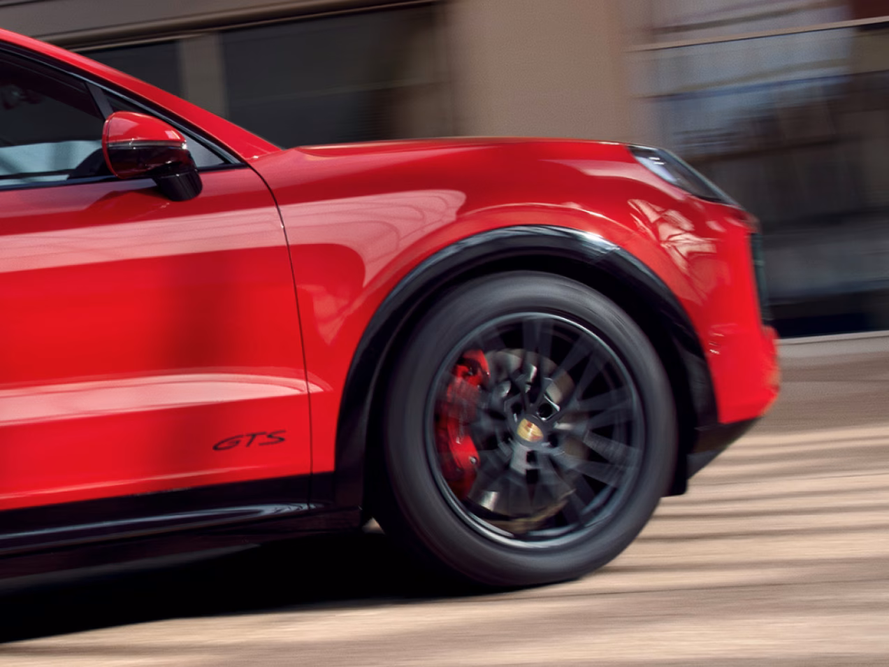 Porsche Cayenne GTS rijdt op de weg. Zicht vanaf de zijkant op het voorwiel.