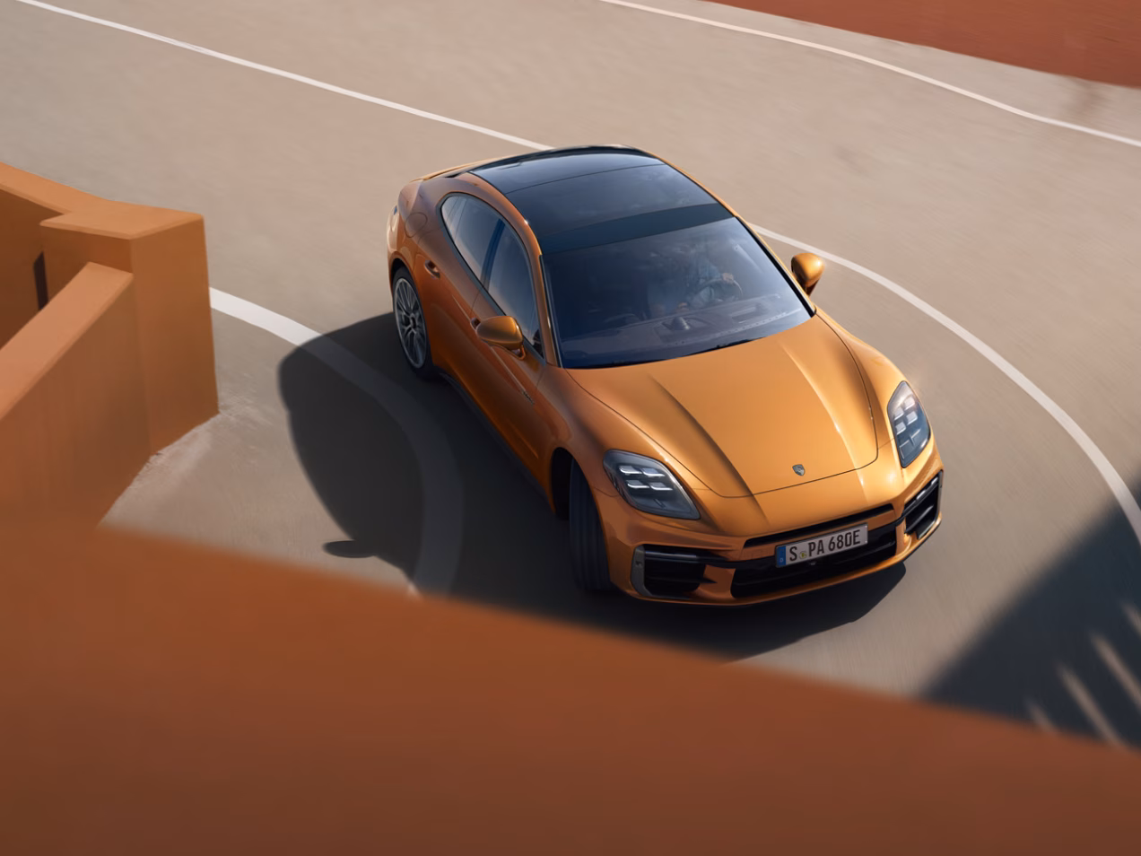 Porsche Panamera Turbo E-Hybrid in Madeira Gold Metallic navigating a tight bend.