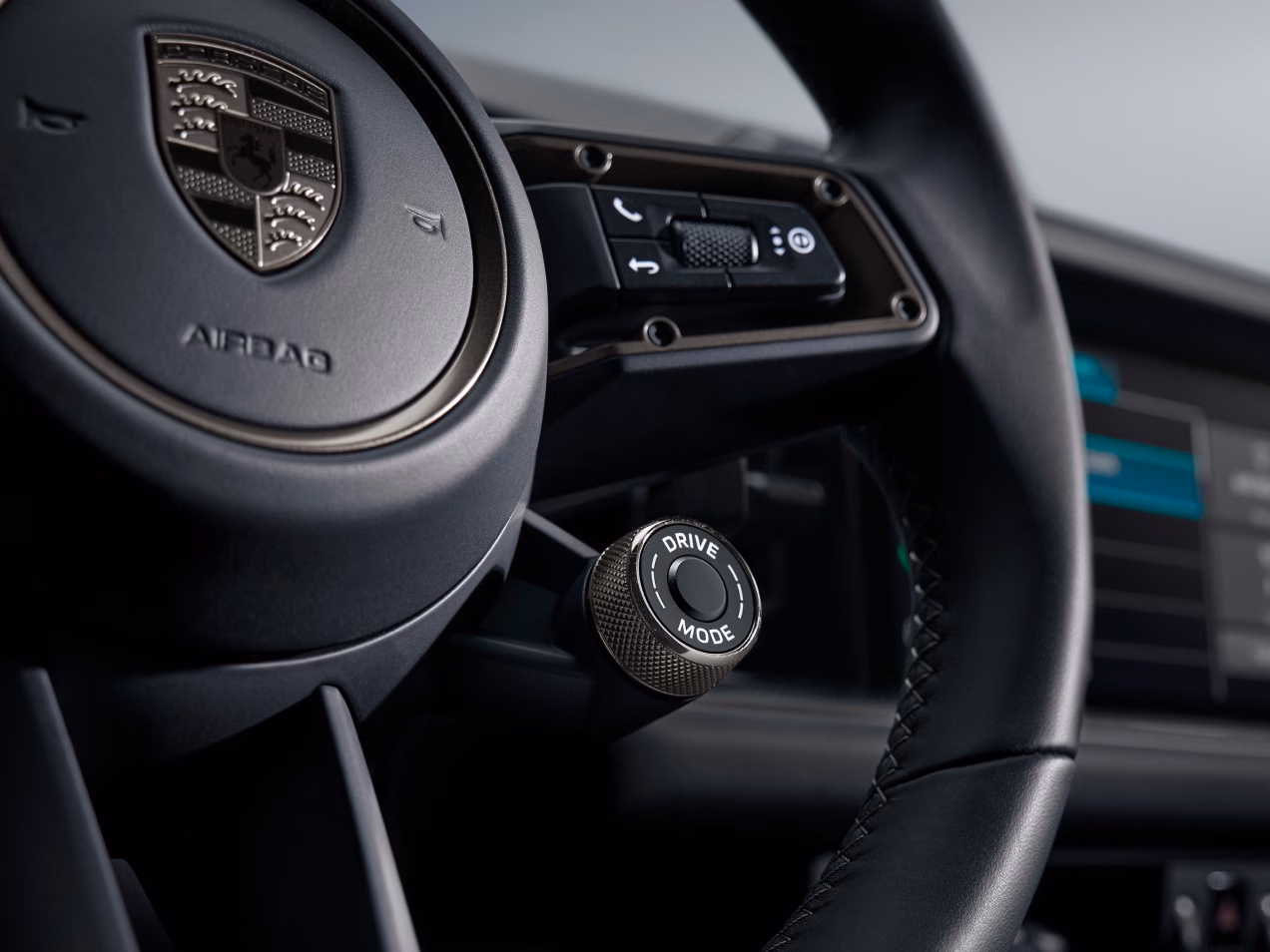 Intérieur du véhicule Porsche Turbo E-Hybrid : vue détaillée du volant avec sélecteur de mode et bouton Sport Response.