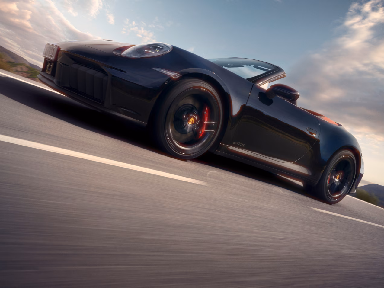 Porsche 911 Carrera GTS Cabriolet in Slate Grey Neo driving on a road. Front and side views.