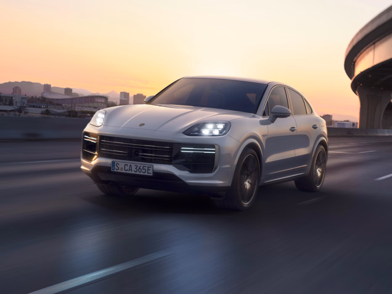 Porsche Cayenne Turbo E-Hybrid, en color Blanco Carrara Metalizado, circula por una carretera nacional. Vista de la parte delantera y el lateral.