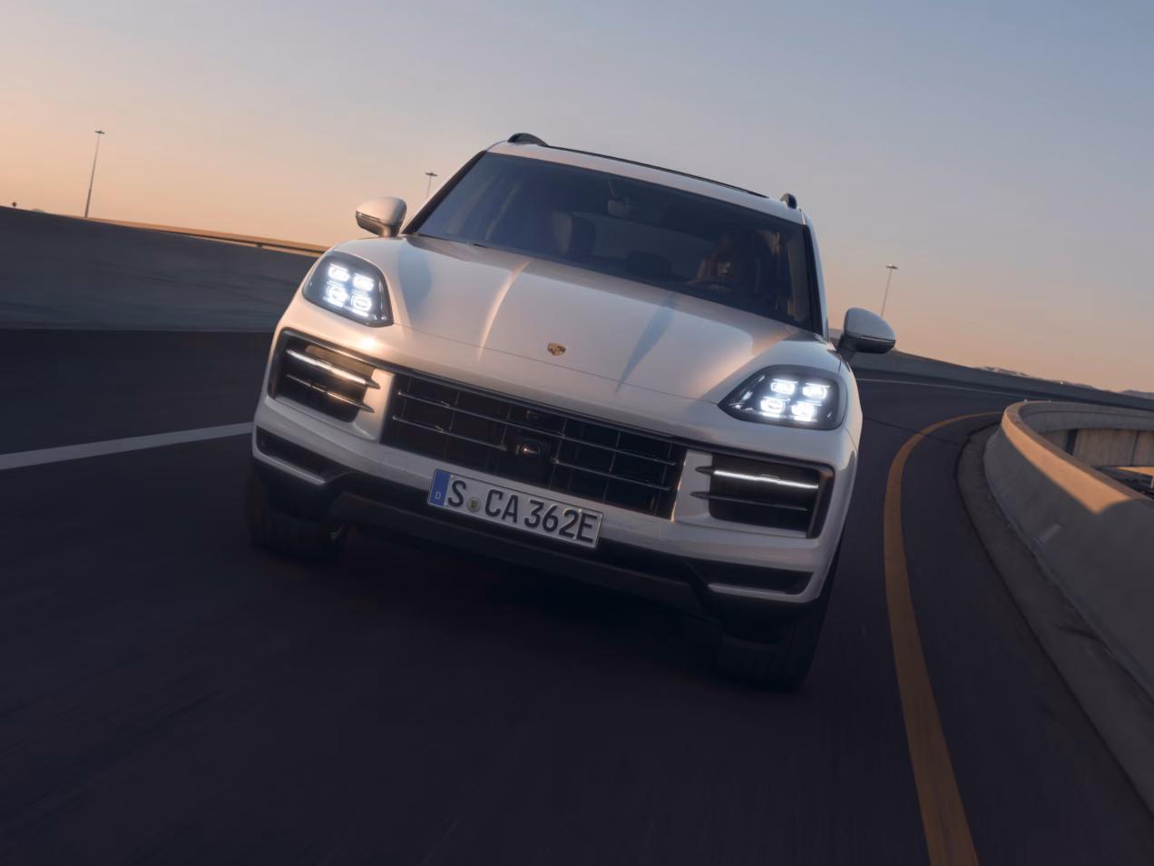 Una Porsche Cayenne S E-Hybrid nel colore bianco Carrara metallizzato in autostrada. Vista frontale.