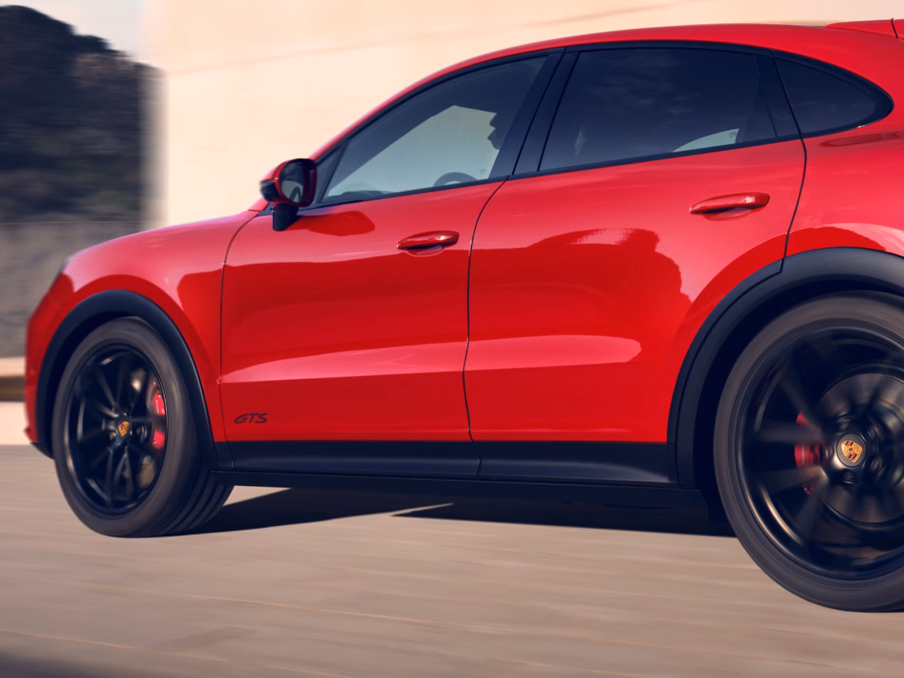 Porsche Cayenne GTS Coupé fährt auf Straße. Blick auf die Seite.