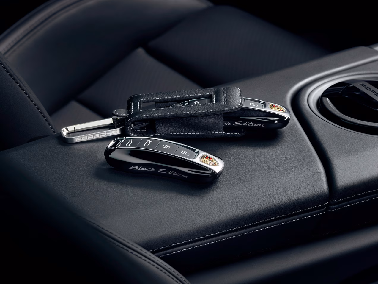 Detailed view of the two driver's keys with 'Black Edition' lettering and the key pouch from the Porsche Taycan 4S Black Edition with Black Edition Extended Package.