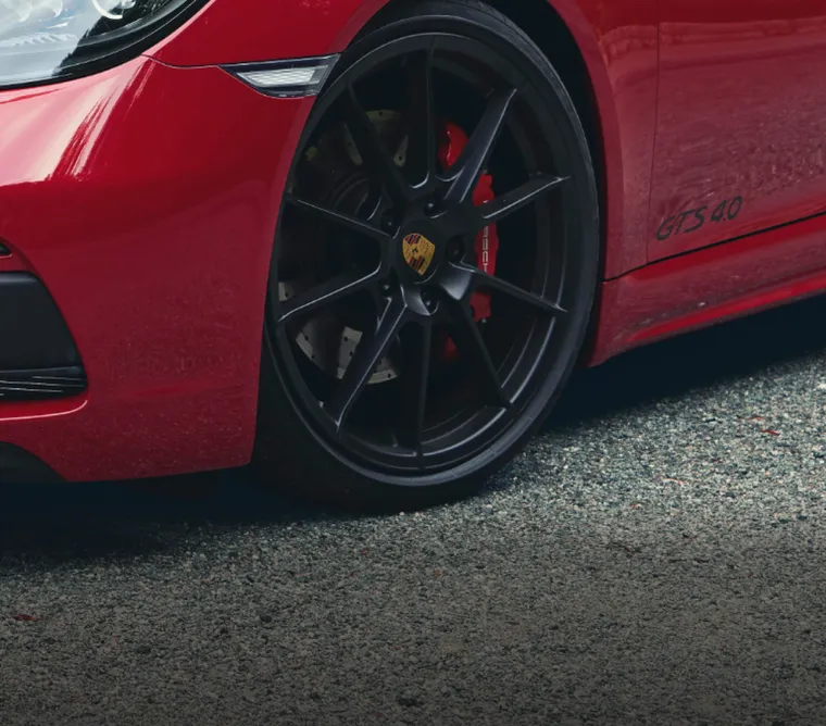 Porsche 718 Cayman GTS 4.0 en Rouge Carmin : gros plan sur la roue avant et le frein.