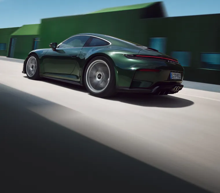 Vy på bakpartiet och sidan av en körande Porsche 911 GT3 Touring i Oak Green Metallic Neo.