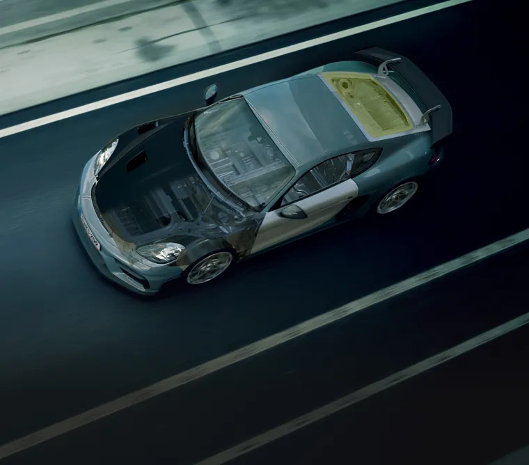 Vista desde arriba del Porsche 718 Cayman GT4 RS en movimiento. La carrocería es parcialmente transparente.