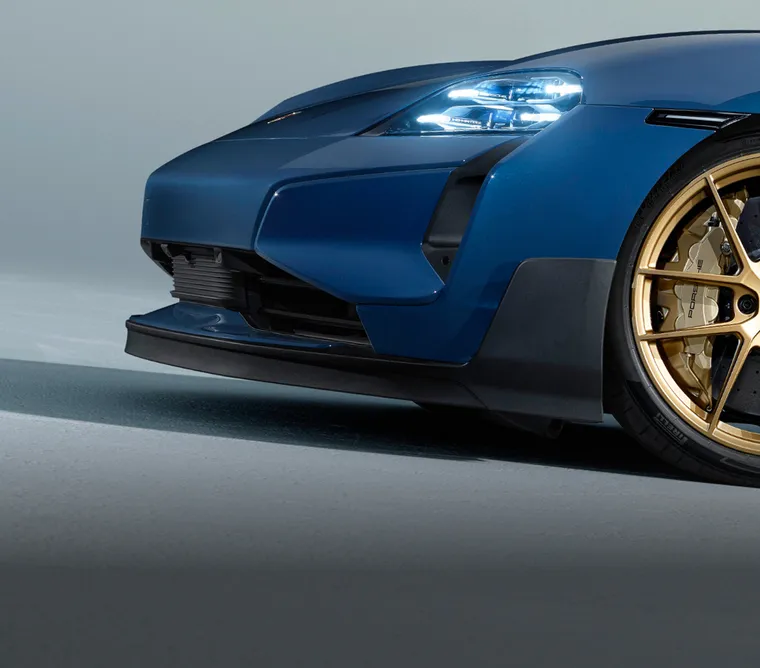 Porsche Taycan Turbo GT in Palebluemetallic vor dunklem Hintergrund beleuchtet. Blick auf die Seite.