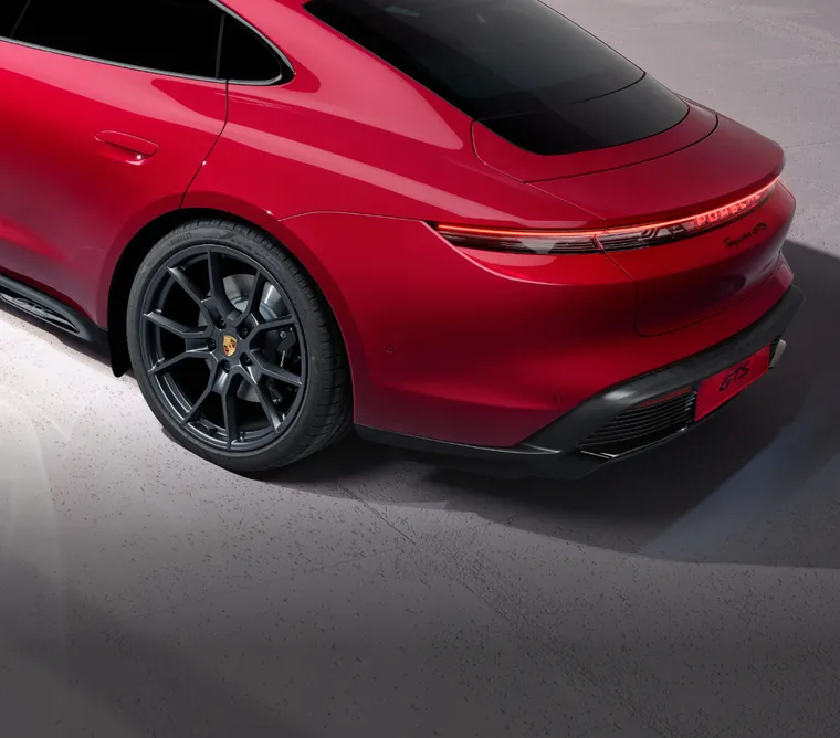 Vy över baksidan och sidan av Porsche Taycan GTS i Carmine Red.