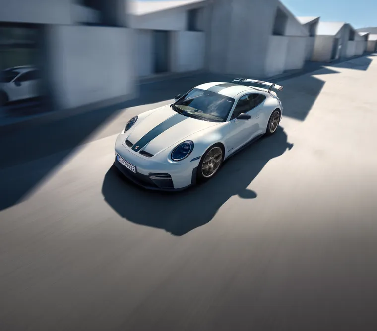 Blick auf Front und Seite eines fahrenden Porsche 911 GT3 in Weiß mit Weissach-Paket.