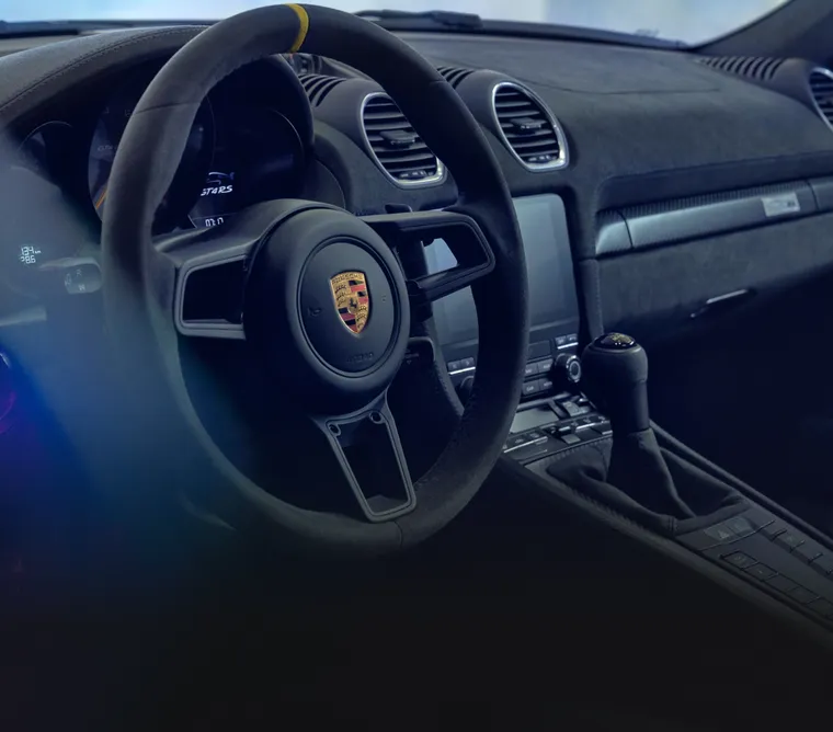 保時捷 718 Cayman GT4 RS 內裝：附黃色 12 點鐘標記的跑車方向盤細節圖