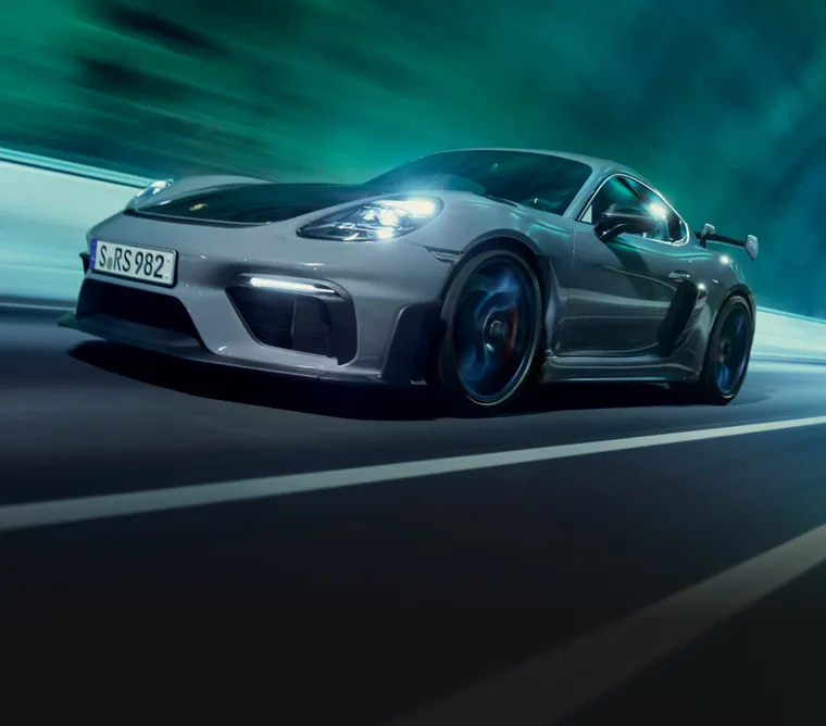 Porsche 718 Cayman GT4 RS en Gris Arctique avec Pack Weissach traversant un tunnel. Vue de face et latérale.