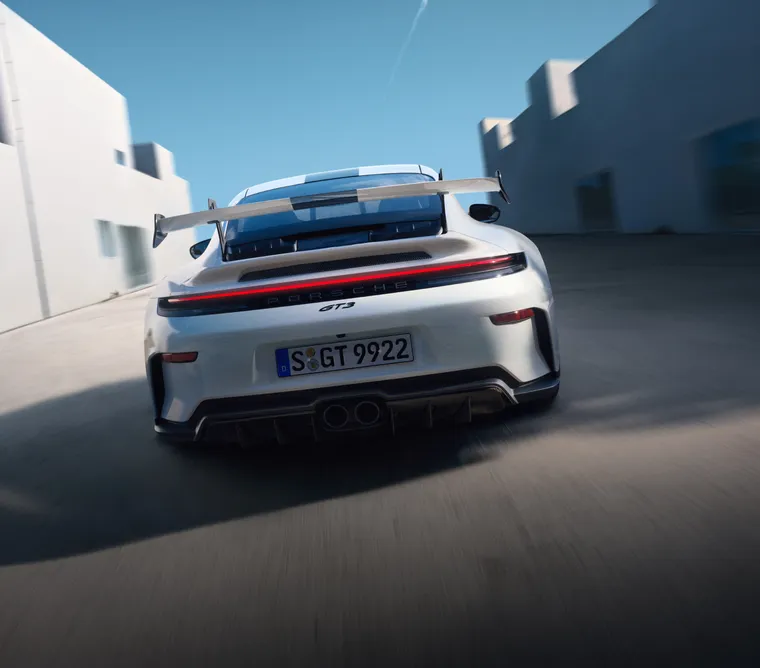 Blick auf das Heck eines fahrenden Porsche 911 GT3 in Weiss.