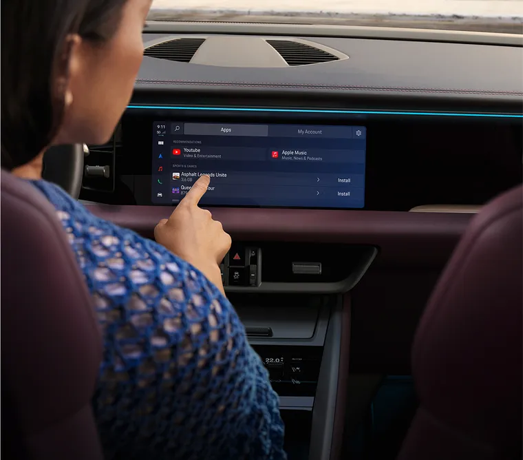Porsche Macan 4 interior. View into the cockpit. Woman using infotainment system.