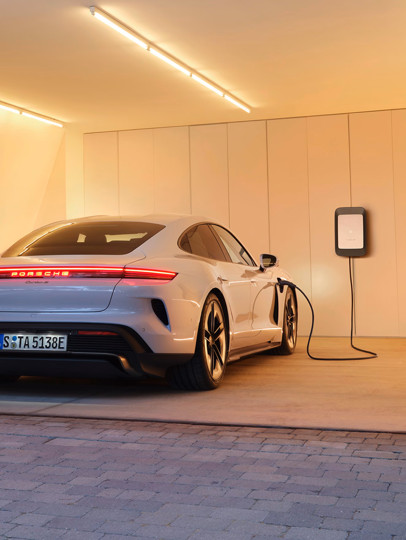 Porsche Taycan Turbo S in Eisgraumetallic steht wird geladen. Blick auf das Heck.