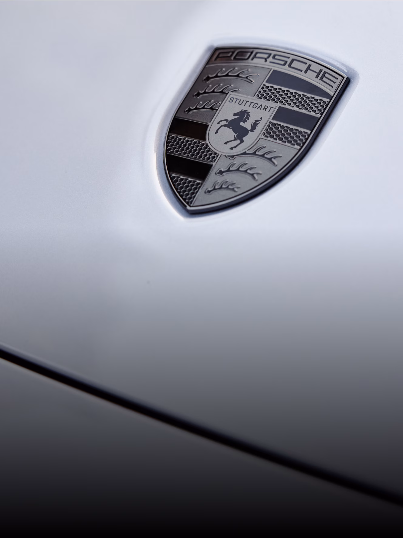 Close-up shot of Porsche Emblem on a Macan Turbo in Ice Grey Metallic