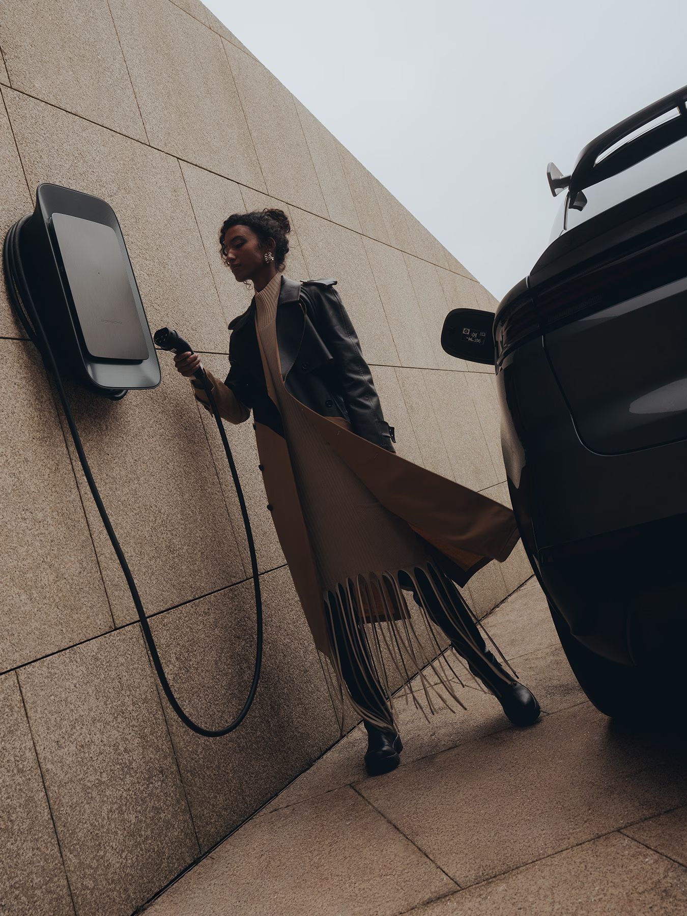 A Taycan Turbo S Sport being charged using a wall charger at home.