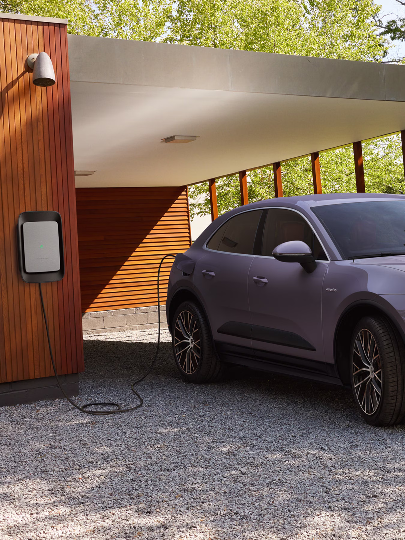 Woman charging her Macan using a wall charger at home.