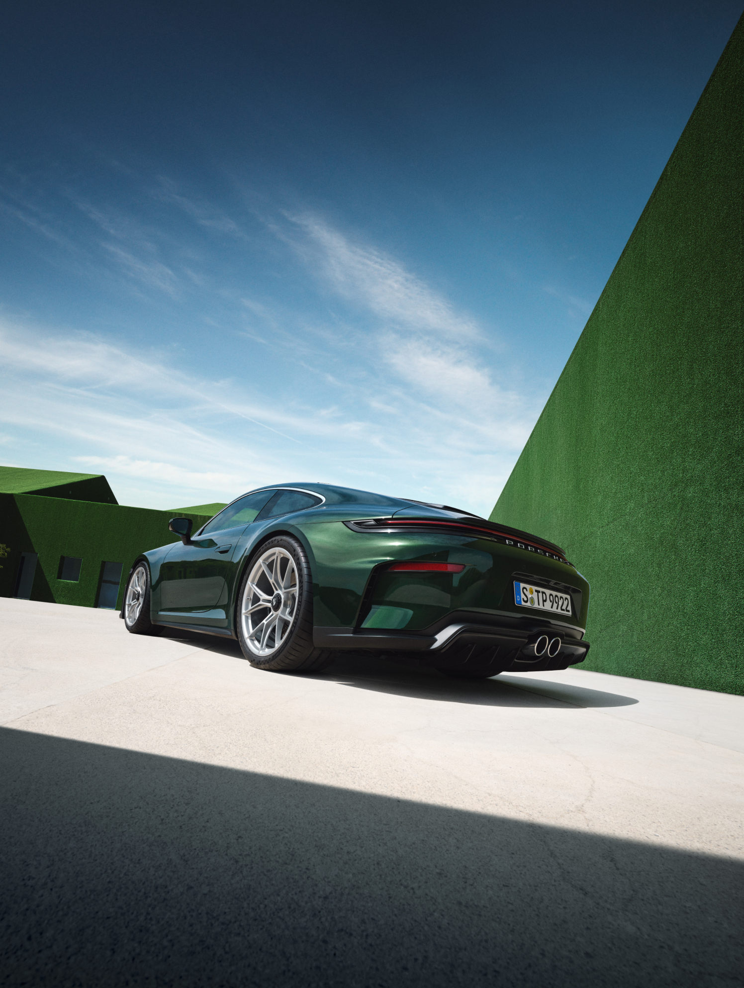 Rear quarter view showing the active pop-up spoiler and quad-exit exhaust