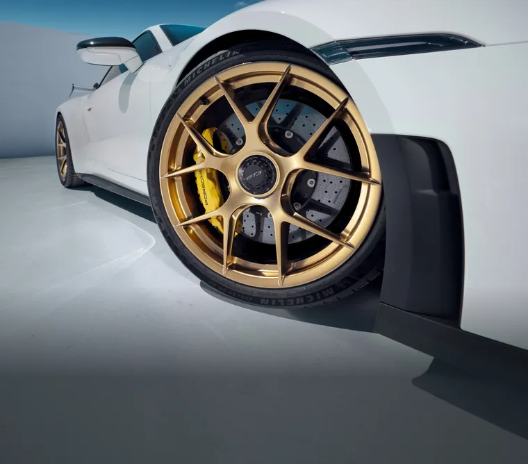 Szczegółowy widok lekkich, kutych obręczy z magnezu w złotym kolorze California Gold (wysoki połysk) w Porsche 911 GT3 z pakietem Weissach.