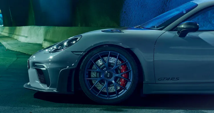 Porsche 718 Cayman GT4 RS en Gris Arctique avec Pack Weissach dans un tunnel. Vue latérale sur l’avant.