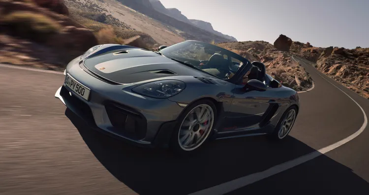 Porsche 718 Spyder RS in Vanadiumgrijs metallic rijdt door de bocht. Zicht op de voorkant en zijkant.