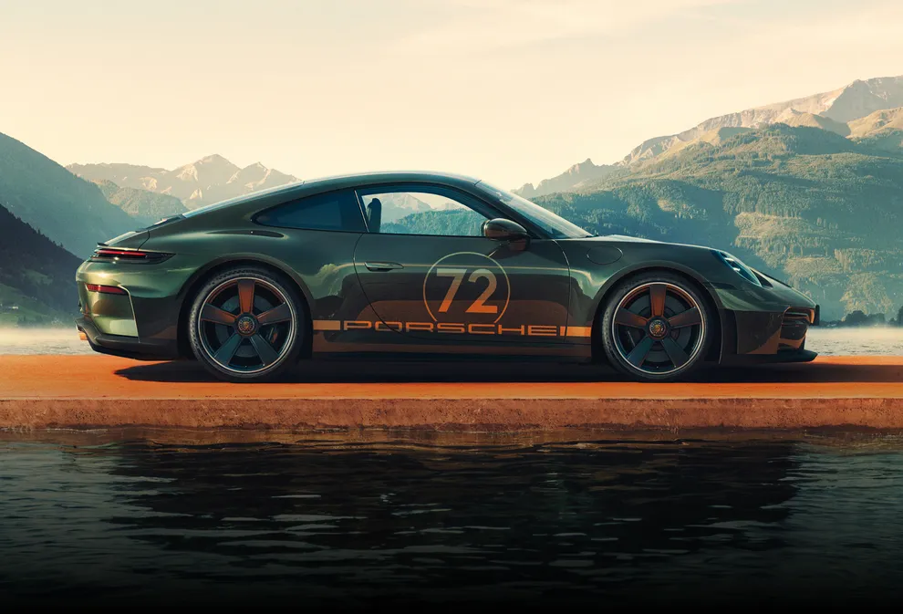 Vista lateral de um Porsche 911 GT3 90 F. A. em F.A. Verde Metalizado num cais. Podem ver-se montanhas e um lago ao fundo.