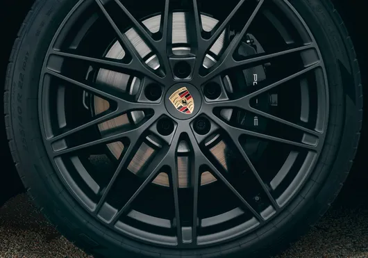 Vista detalhada do freio monobloco de alumínio de seis pistões com pinça fixa e pinça de freio preta no Porsche Macan GTS.