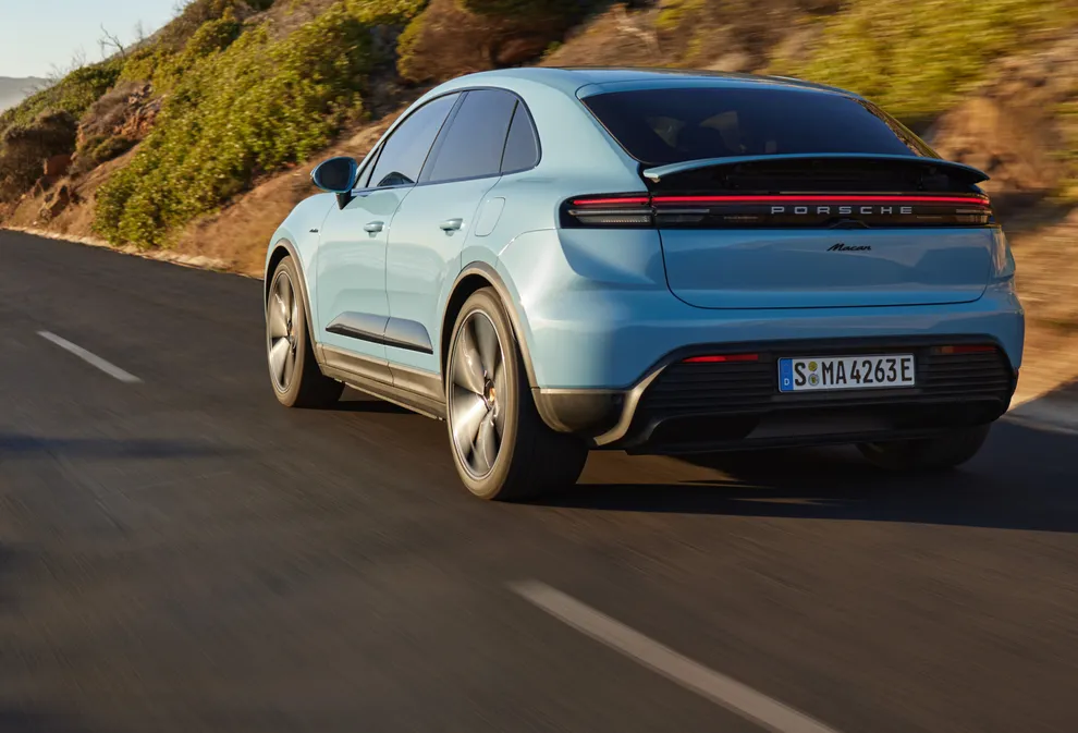 Porsche Macan 4 in Provence fährt durch Vorstadt. Seite und Front sichtbar.