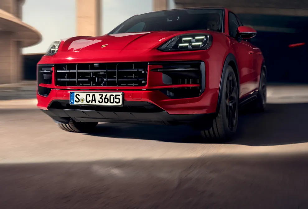 View of the front of a moving Porsche Cayenne GTS Coupé in Carmine Red.