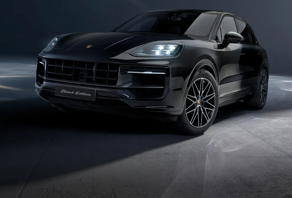 Vooraanzicht van de voor- en zijkant van een Porsche Cayenne Black Edition in Chromite zwart metallic.