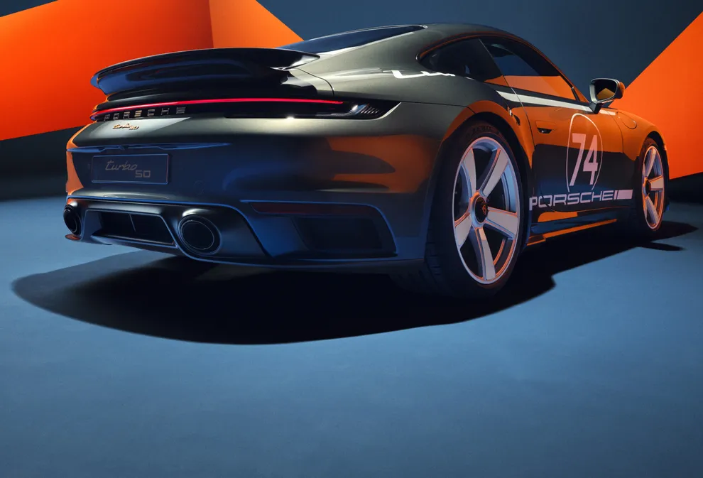 Der Porsche 911 Turbo 50 Jahre mit Heritage Design Paket wird seitlich von hinten gezeigt. 