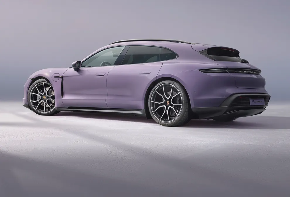 Porsche Taycan 4S Sport Turismo in Provence wird vor dunklem Hintergrund angestrahlt. Blick auf die Seite. 