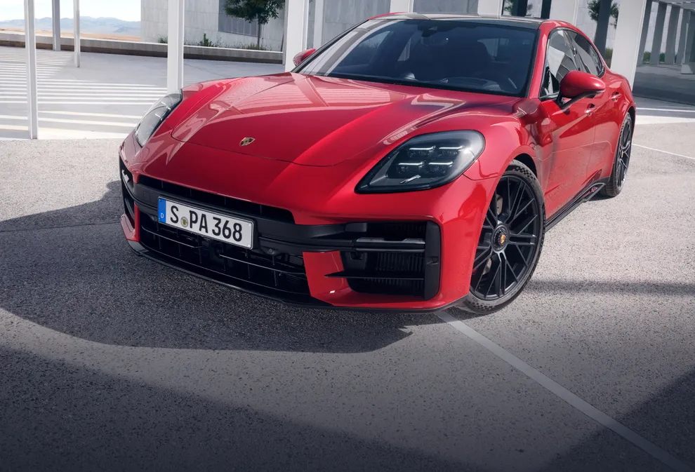La Porsche Panamera GTS in Rosso Carminio in città. Vista dal davanti sul frontale e sul laterale.