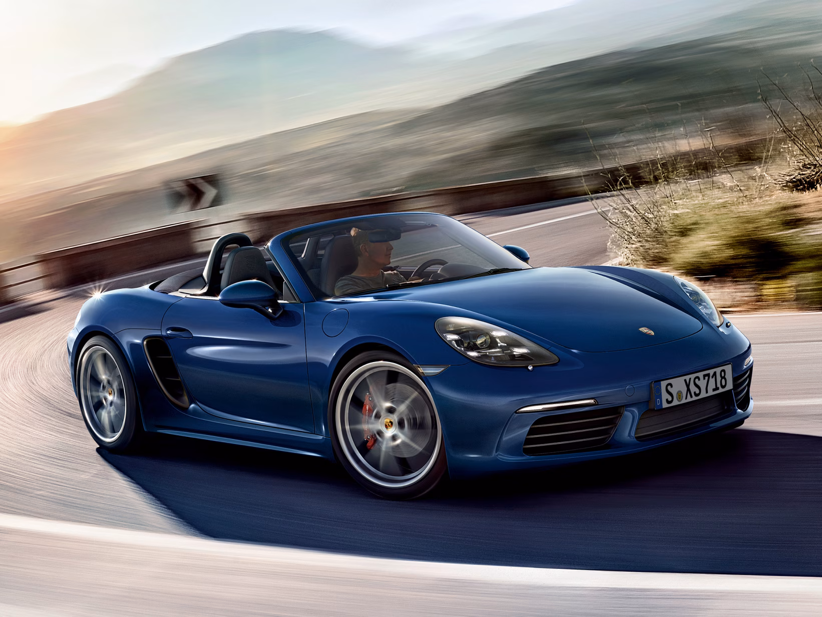 Porsche 718 Boxster S driving through the countryside.